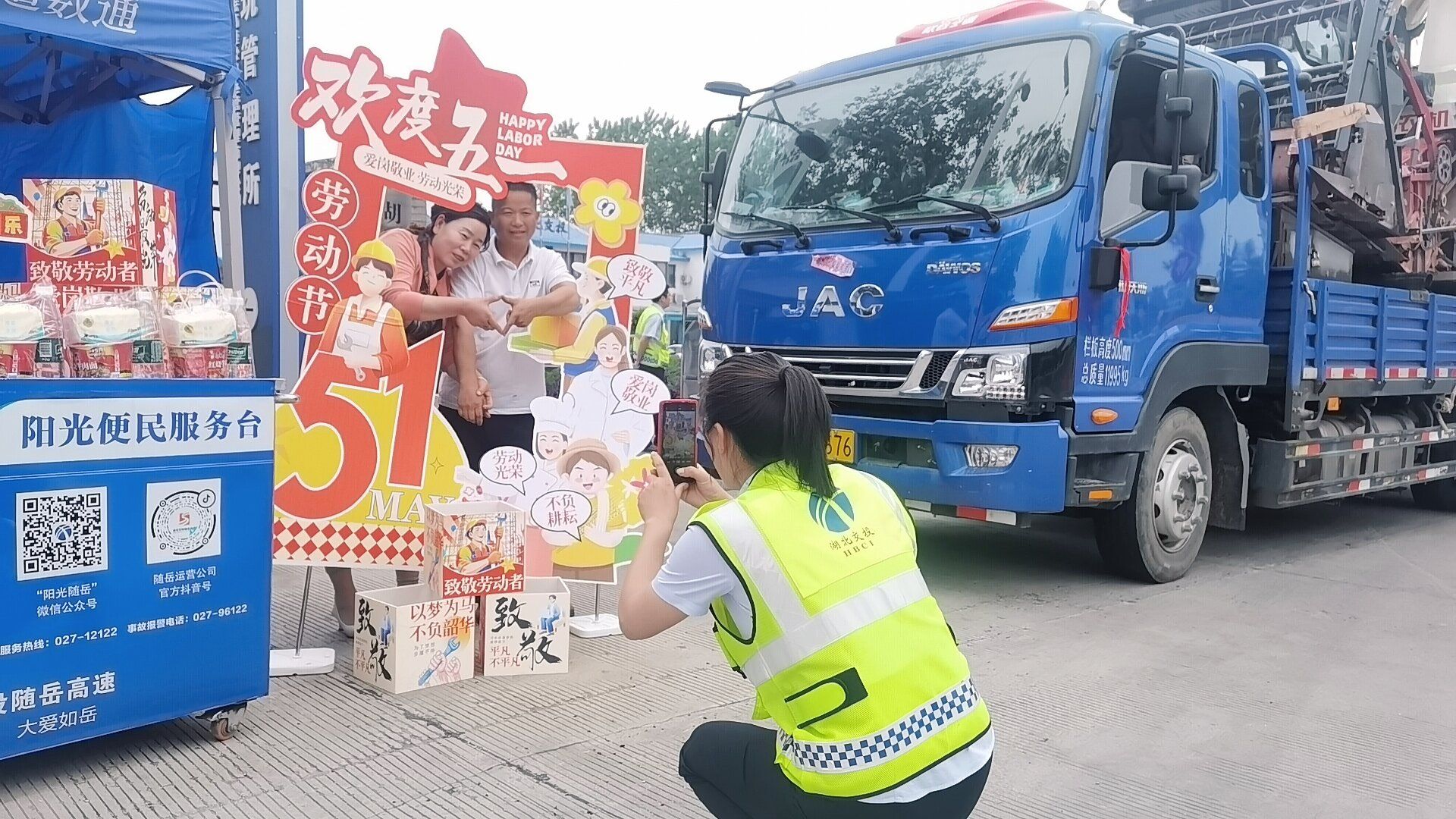 随岳运营公司在收费广场设置节日打卡点，工作人员为司乘提供拍照等服务_proc.jpg.jpg